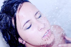 Eine junge Frau unter der Dusche